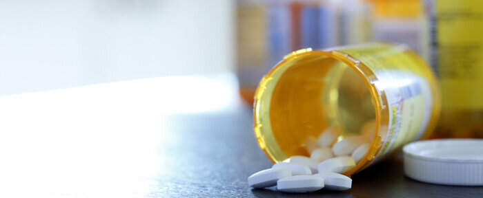 Spilled pill bottle with blurred pill bottles in the background