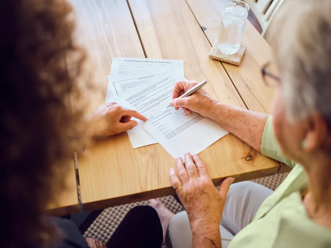 Older woman signing estate planning documents