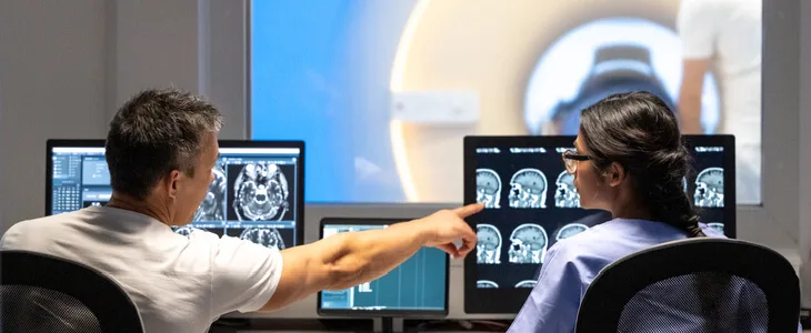 two doctors looking over a brain scan result