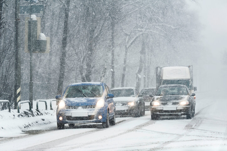Cars driving down a snowy road