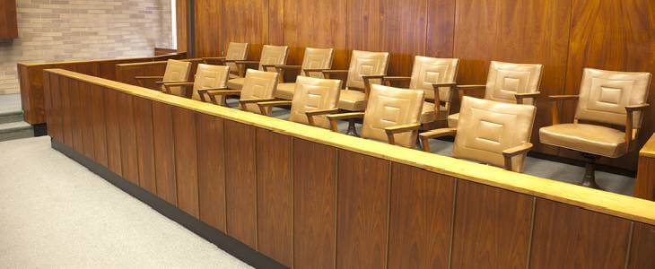 Brightly lit courtroom with empty juror chairs
